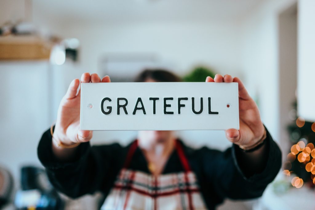 Man holding up sign saying grateful