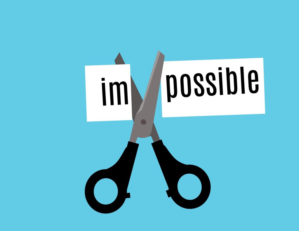 scissors cutting the word impossible